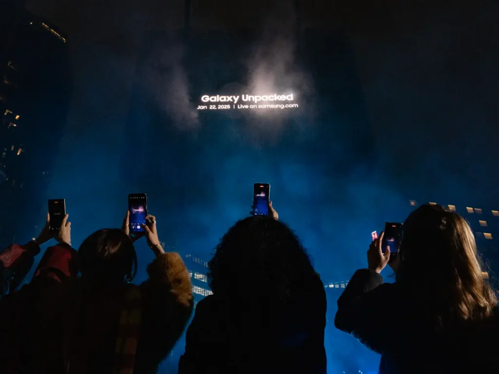 a group of people taking a picture of a concert. Samsung Unpacked 2025. {Tech} for Travel. https://techfortravel.co.uk