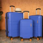 Suitcase and Carry On, When to Pack One or Both? a group of blue suitcases with wheels and a hat on top