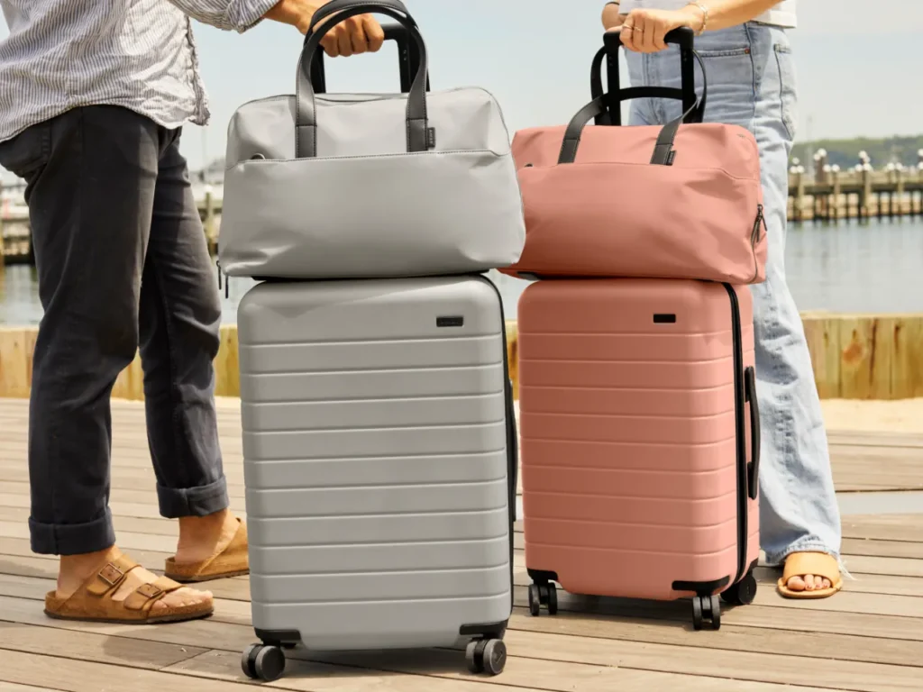 a group of people holding luggage. Away Suitcases. {Tech} for Travel. https://techfortravel.co.uk