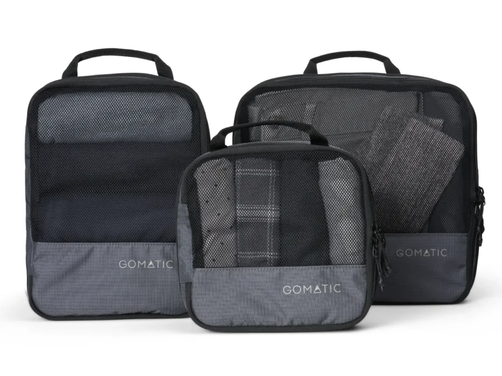 a group of black and grey luggage bags. Gomatic Packing Cubes. Nomatic Packing Cubes. Gomatic Accessories. {Tech} for Travel. https://techfortravel.co.uk