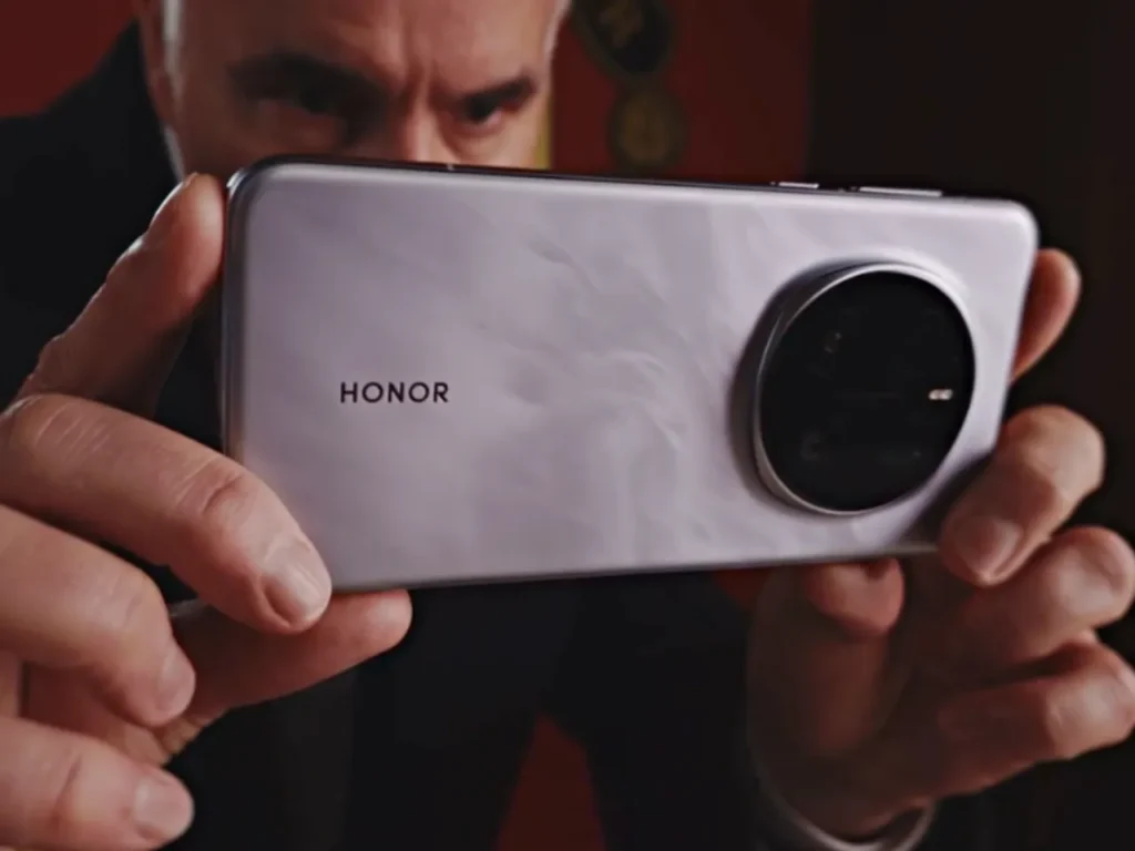 a man holding a silver rectangular device. HONOR Snapdragon and Manchester United partnership.  {Tech} for Travel. https://techfortravel.co.uk