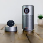 Nebula Capsule Air Review: A Smart Mini Projector a grey speaker on a wooden surface. Nebula Capsule Air Review.