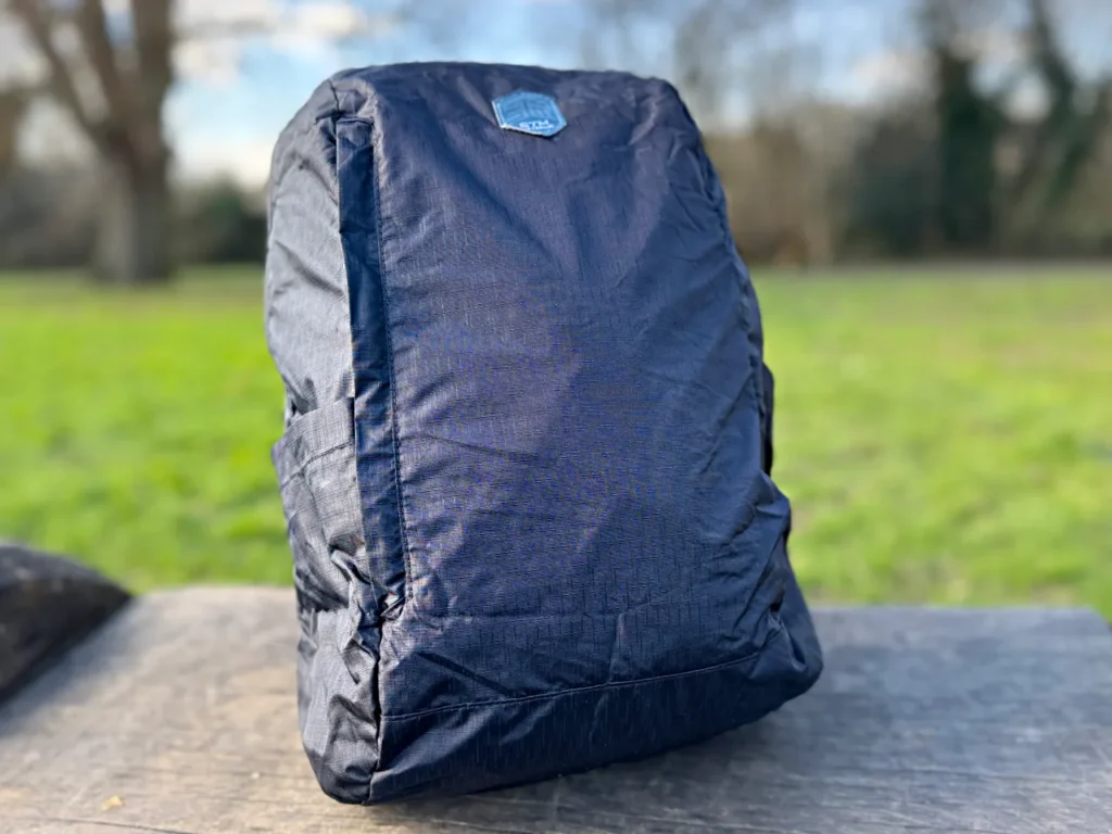 a black backpack on a wood surface. STM Goods BagPack Review. {Tech} for Travel. https://techfortravel.co.uk