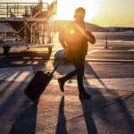 How to Choose the Best Carry On Suitcase for Travel a man pulling a suitcase