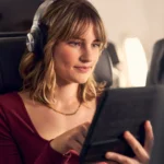 a woman wearing headphones and using a tablet. American Airlines Free Wi-Fi