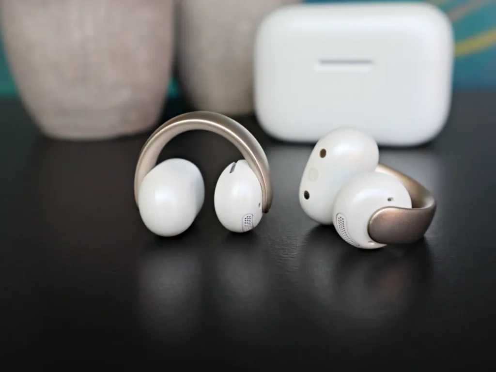a pair of white headphones on a black surface. Soundcore Aeroclip review. {Tech} for Travel. https://techfortravel.co.uk