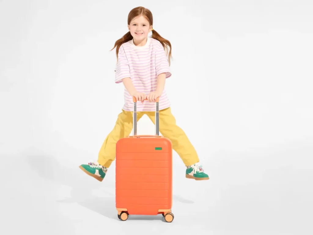 Away Kids Collection Carry-On – {Tech} for Travel a girl with a suitcase. Away Kids Collection. {Tech} for Travel. https://techfortravel.co.uk