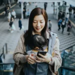 a woman holding a baby on a cellphone. Fly Delta App version 7. {Tech} for Travel. https://techfortravel.co.uk