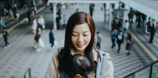 Fly Delta App Version 7 Update Introduces SkyMiles Perks a woman holding a baby on a cellphone. Fly Delta App version 7. {Tech} for Travel. https://techfortravel.co.uk