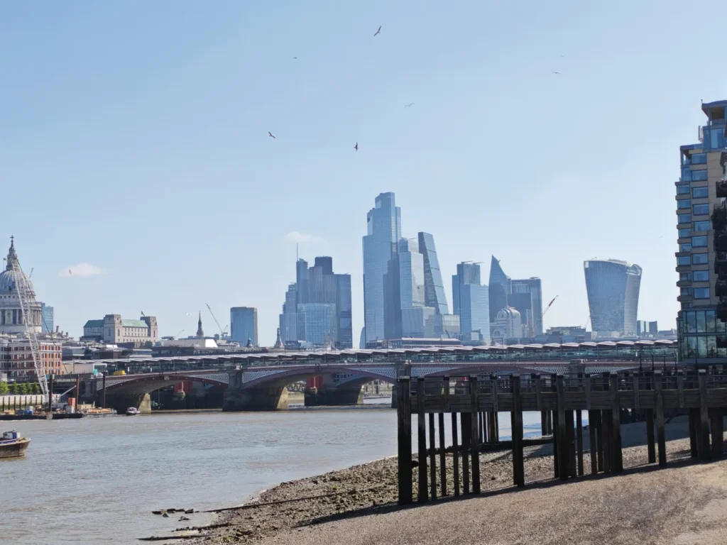 a bridge over a river with a city in the background