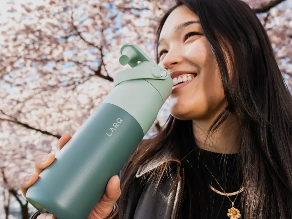 LARQ PureVis 2 – {Tech} for Travel a woman drinking from a water bottle. LARQ PureVis 2. Healthy Travel Gadgets. {Tech} for Travel. https://techfortravel.co.uk