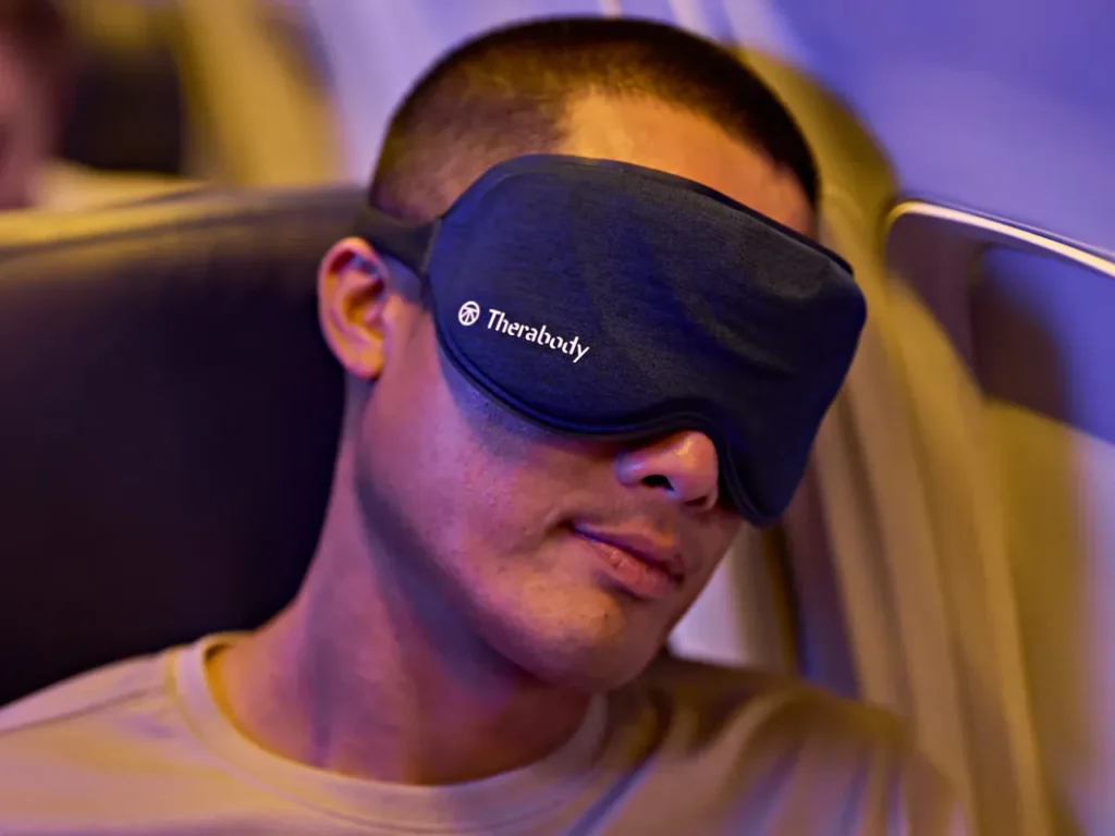 Therabody SleepMask – {Tech} for Travel a man wearing a mask. Therabody SleepMask. Healthy Travel Gadgets. {Tech} for Travel. https://techfortravel.co.uk
