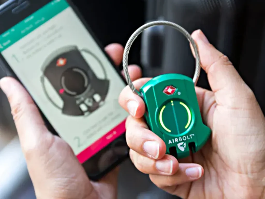 Airbolt Lock – {Tech} for Travel a person holding a device. Best Luggage Tracker. AirBolt Lock. {Tech} for Travel. https://techfortravel.co.uk
