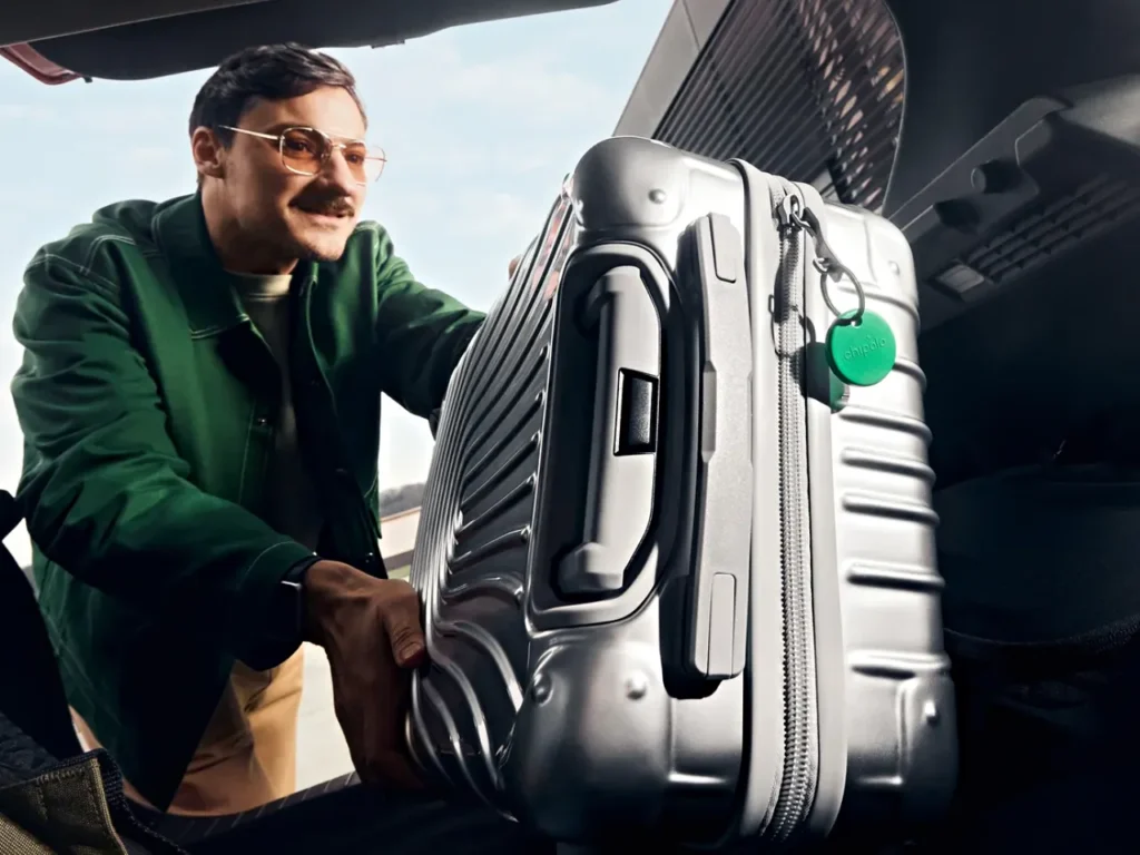 Chipolo Pop – {Tech} for Travel a man with mustache holding a suitcase in the back of a car. Best Luggage Tracker. Chipolo Pop Tracker. {Tech} for Travel. https://techfortravel.co.uk