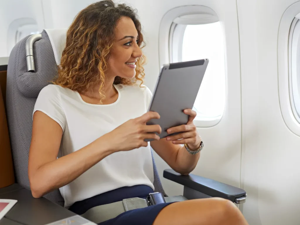 Lufthansa Messaging Service – {Tech} for Travel a woman sitting in a chair looking at a tablet. Lufthansa Wi-Fi Free Messaging. {Tech} for Travel. https://techfortravel.co.uk