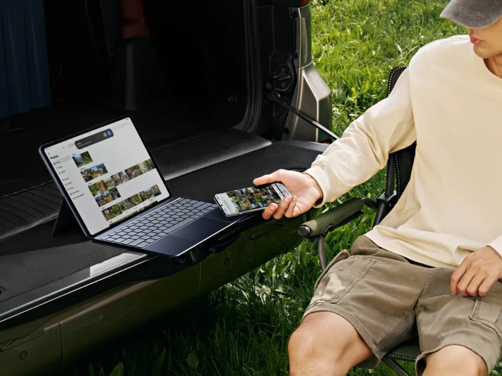 OnePlus Pad 3 Outdoors – {Tech} for Travel a man sitting in a chair with a laptop and phone in the back of a truck. OnePlus Pad 3 review. {Tech} for Travel. https://techfortravel.co.uk