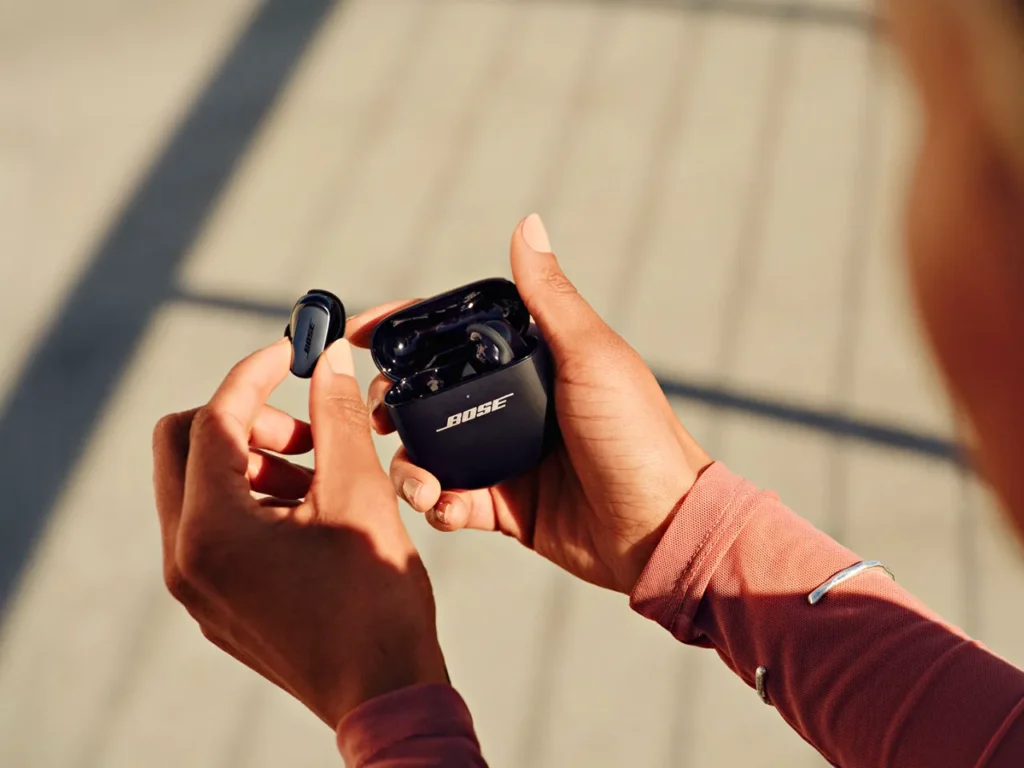 QuietComfort Ultra Earbuds 2nd Gen Black with case – {Tech} for Travel a person holding a wireless earbuds. Bose QuietComfort Ultra Earbuds 2nd Gen. {Tech} for Travel. https://techfortravel.co.uk