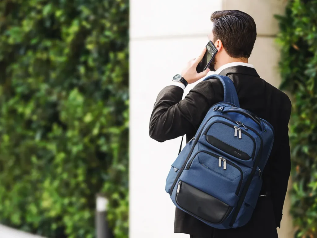 Targus HeritageLuxe Backpack Hero – {Tech} for Travel a man with a backpack talking on a cell phone. Targus HeritageLuxe Backpack. {Tech} for Travel. https://techfortravel.co.uk