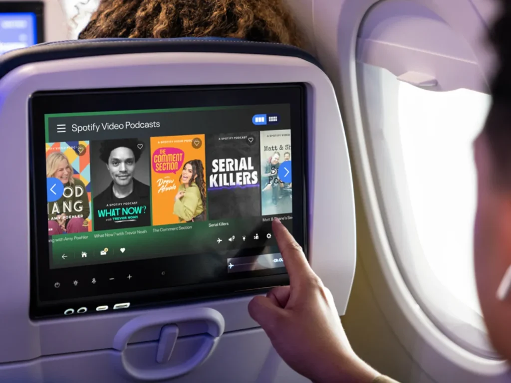 United Airlines Spotify Display – {Tech} for Travel a person using a touch screen device. United Airlines Spotify. {Tech} for Travel. https://techfortravel.co.uk