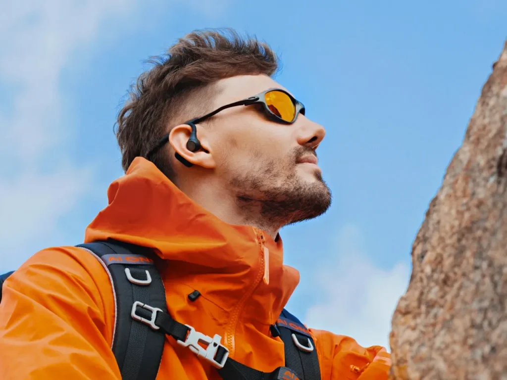 Openrock S2 Hero – {Tech} for Travel a man wearing sunglasses and a backpack. OpenRock S2 Earbuds review. {Tech} for Travel. https://techfortravel.co.uk