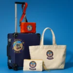 Globe-Trotter Explorer Carry-On headlines new collection a blue suitcase with a red and yellow logo on it. Globe-Trotter Explorer Carry-On collection. {Tech} for Travel. https://techfortravel.co.uk
