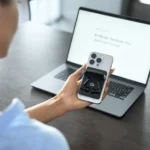 IFA 2025: Komutr MagSafe Earbuds Are Built for Commuters a person holding a phone and a laptop. Komutr MagSafe earbuds. IFA 2025 News. {Tech} for Travel. https://techfortravel.co.uk