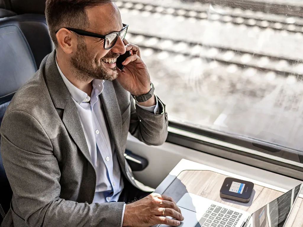 Netgear M7 Pro Travel Router Train – {Tech} for Travel a man in a suit talking on a phone. M7 Pro Travel Router. IFA 2025 news. {Tech} for Travel. https://techfortravel.co.uk
