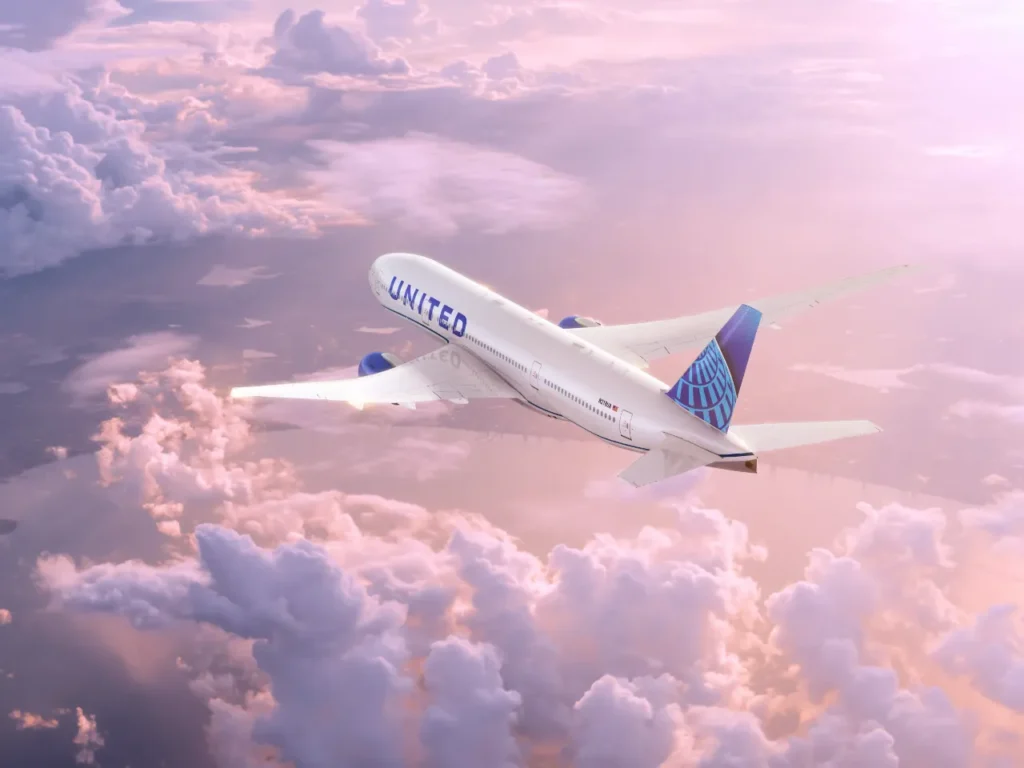 United Airlines 777 – {Tech} for Travel an airplane flying in the sky. United Airlines Apple TV+. {Tech} for Travel. https://techfortravel.co.uk