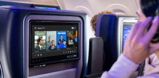 Apple TV+ shows hit the skies with United Airlines a man sitting in an airplane with a television screen. United Airlines Apple TV. {Tech} for Travel. https://techfortravel.co.uk