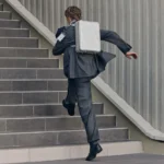First look at the new RIMOWA Original Backpack a man running up stairs with a briefcase. RIMOWA Original Backpack. {Tech} for Travel. https://techfortravel.co.uk