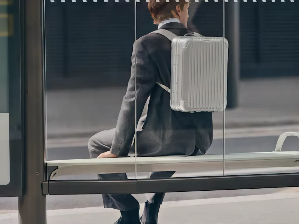a man sitting on a bus stop. RIMOWA Original Backpack. {Tech} for Travel. https://techfortravel.co.uk