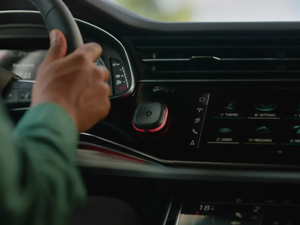 a hand on a steering wheel in a car. speed camera warning device. Tom by TomTom. {Tech} for Travel. https://techfortravel.co.uk