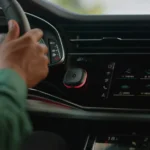 a hand on a steering wheel in a car. speed camera warning device. Tom by TomTom. {Tech} for Travel. https://techfortravel.co.uk