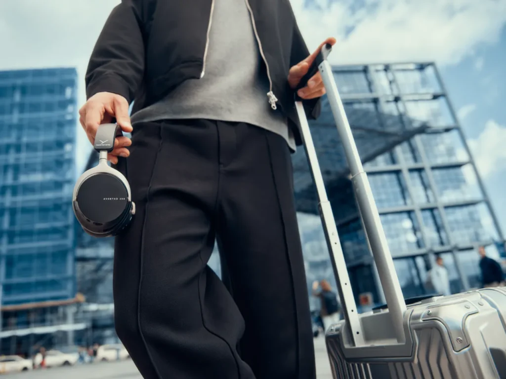 beyerdynamic AVENTHO 200 lifestyle – {Tech} for Travel a person holding a luggage. beyerdynamic AVENTHO 200 ANC Headphones. {Tech} for Travel. https://techfortravel.co.uk