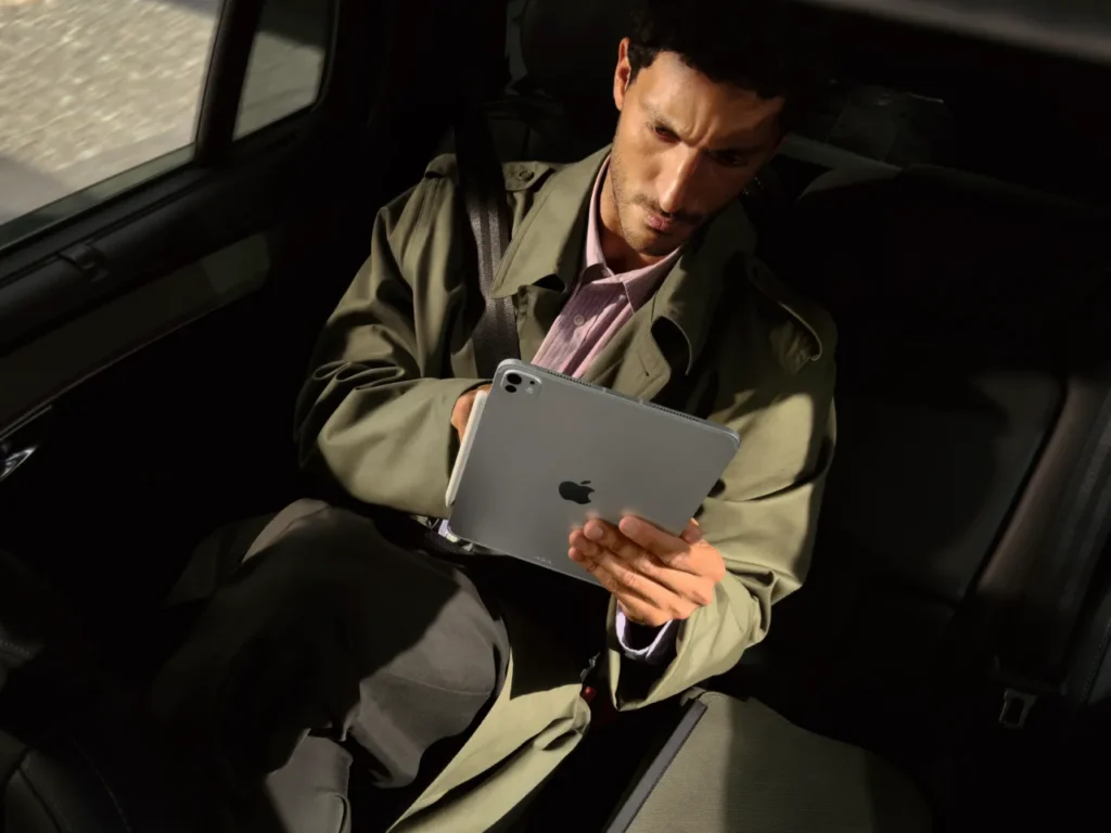 Apple iPad Pro M5 Lifestyle – {Tech} for Travel a man sitting in a car holding a tablet. Apple iPad Pro M5. {Tech} for Travel. https://techfortravel.co.uk