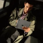 Apple iPad Pro M5 launched with new M5 chip and AI boost a man sitting in a car holding a tablet. Apple iPad Pro M5. {Tech} for Travel. https://techfortravel.co.uk