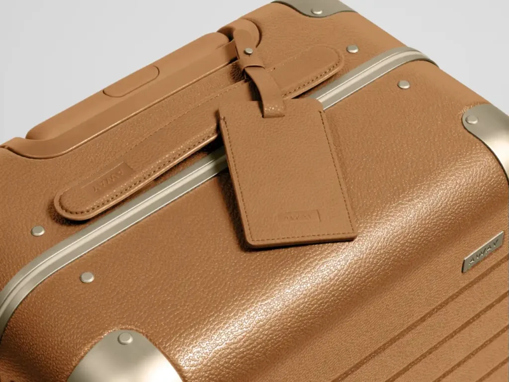 Away Aluminum Collection Cognac Brown – {Tech} for Travel a brown suitcase with a tag on it. Away Aluminum Edge Collection. {Tech} for Travel. https://techfortravel.co.uk