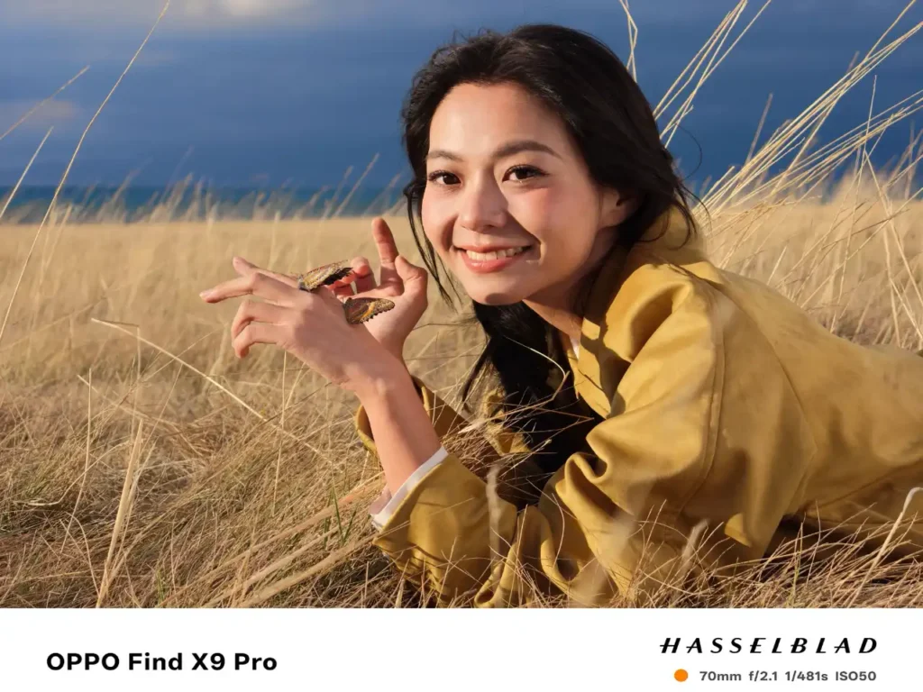 a woman lying in a field holding a small turtle