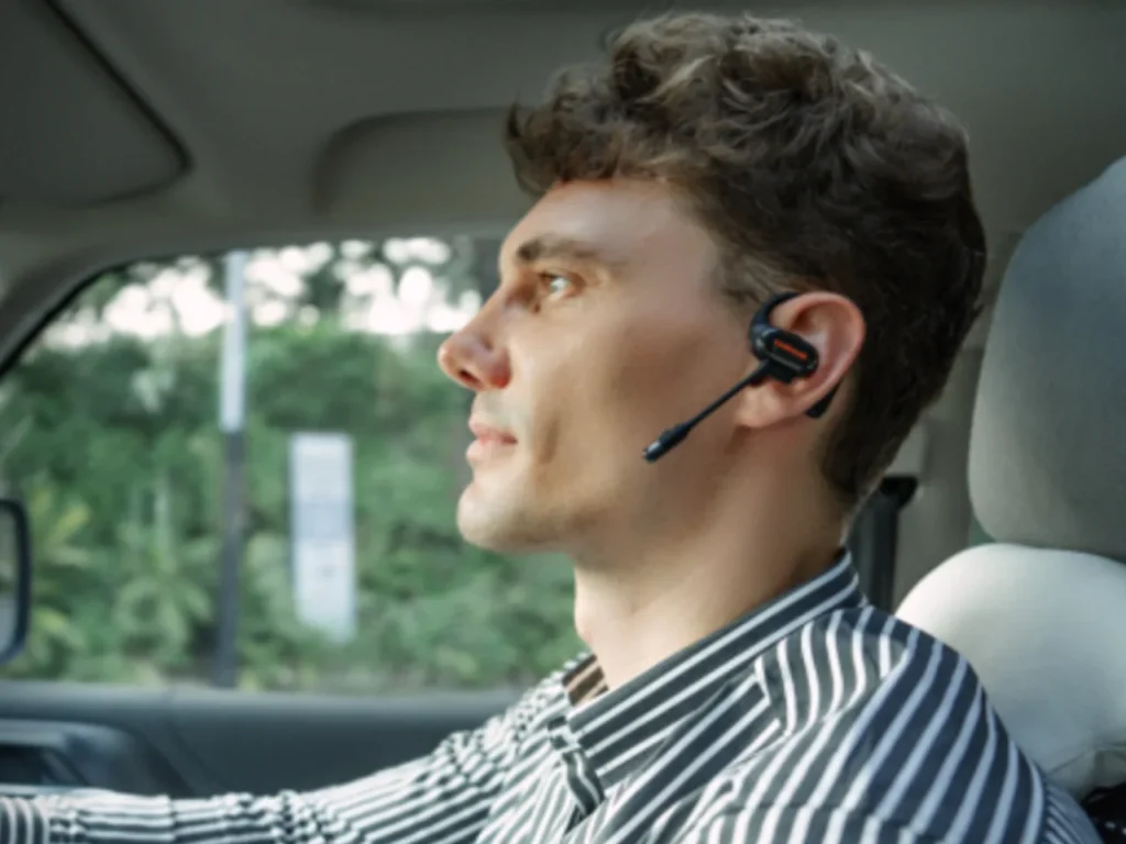 OpenRock Link 20 Lifestyle – {Tech} for Travel a man wearing a headset in a car. OpenRock Link 20 Earbuds. {Tech} for Travel. https://techfortravel.co.uk