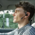 OpenRock Link 20 Earbuds Launch with Magnetic Boom Mic a man wearing a headset in a car. OpenRock Link 20 Earbuds. {Tech} for Travel. https://techfortravel.co.uk