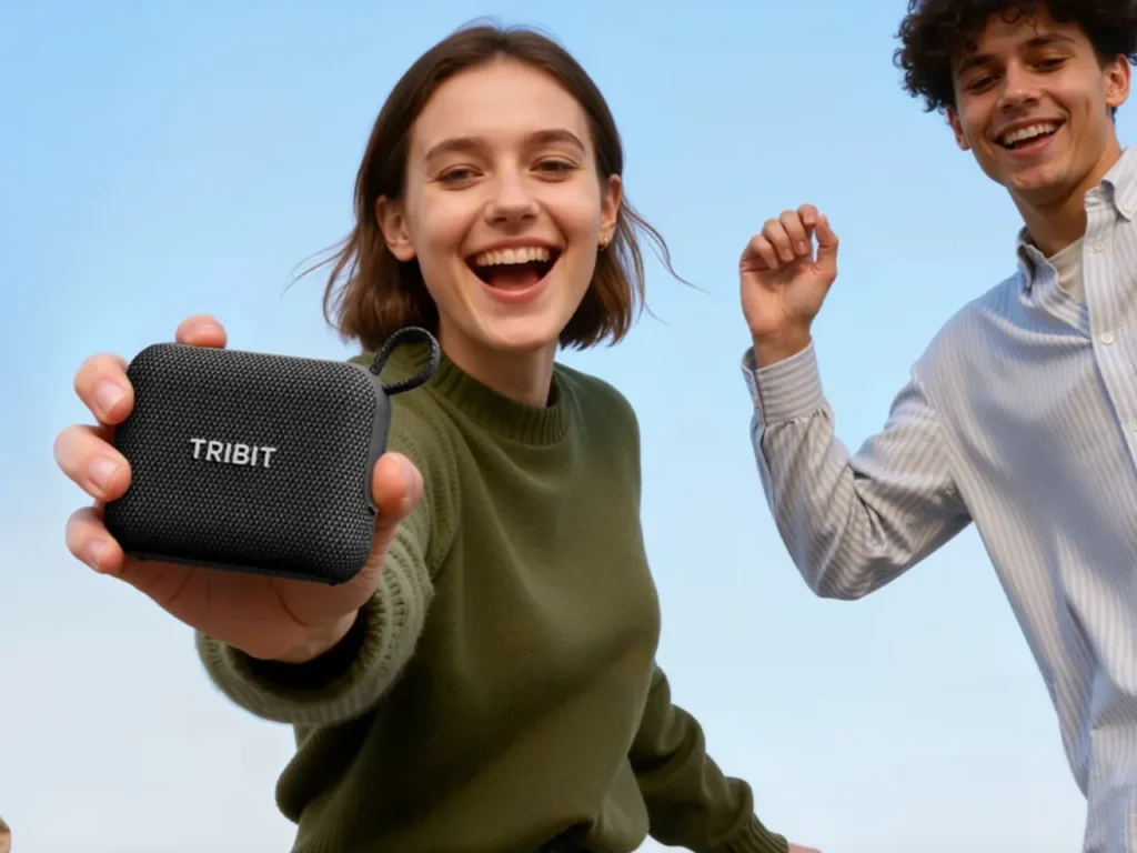 Tribit PocketGo – {Tech} for Travel a woman holding a small black speaker. best travel gifts for Christmas 2025. {Tech} for Travel. https://techfortravel.co.uk