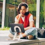 Twelve South Curve Mini makes iPad more productive on-the-go a woman sitting on a step with headphones on. Twelve South Curve Mini. {Tech} for Travel. https://techfortravel.co.uk
