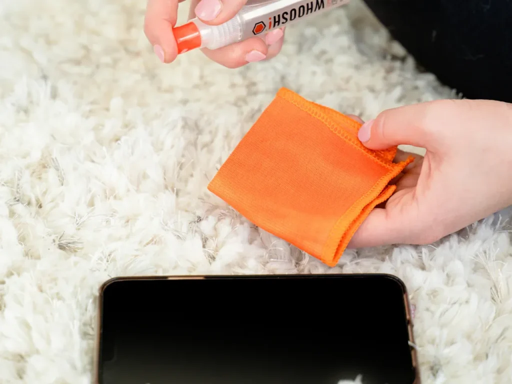 Whoosh Screen Shine Go – {Tech} for Travel a person cleaning a cloth with a spray bottle. best travel gifts for Christmas 2025. {Tech} for Travel. https://techfortravel.co.uk