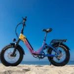 a purple and yellow bike on a beach. Heybike X Series. CES 2026 News. {Tech} for Travel. https://techfortravel.co.uk