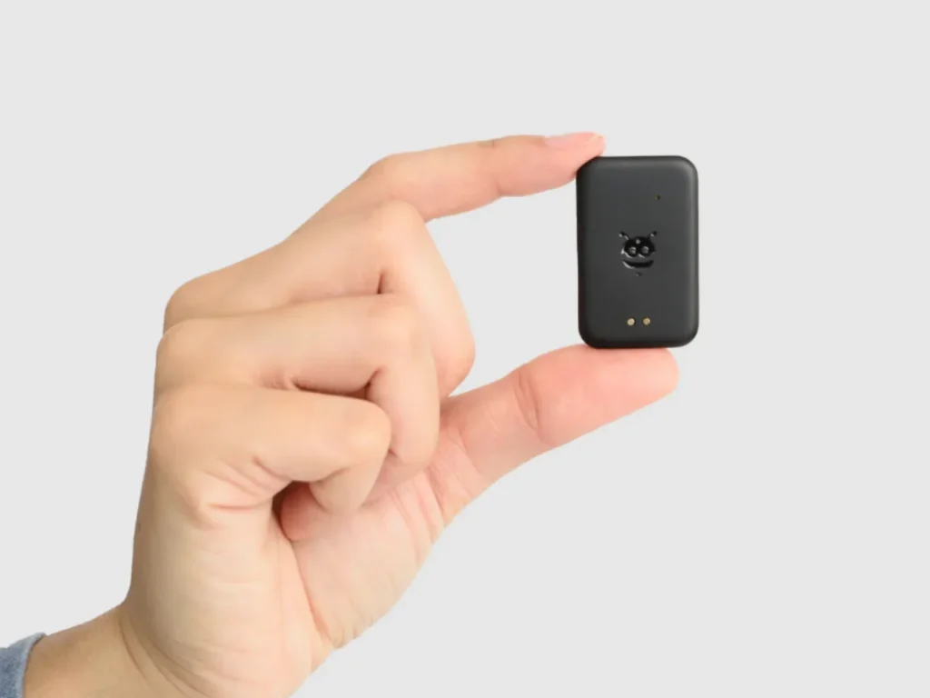 a hand holding a small black object. Pebblebee Tag. Best Travel Gadgets 2025. {Tech} for Travel. https://techfortravel.co.uk