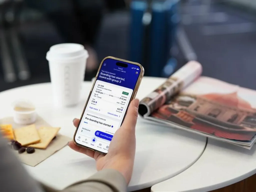 a person holding a phone. United Airlines app. {Tech} for Travel. https://techfortravel.co.uk