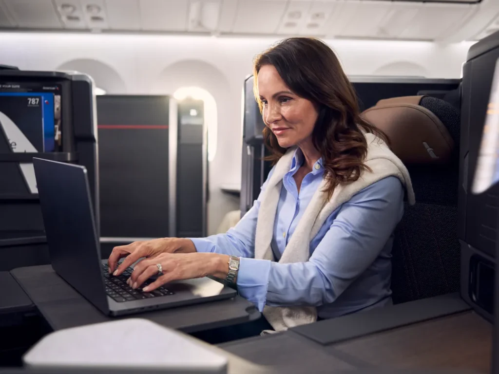American Airlines Wi-Fi Service – {Tech} for Travel a woman sitting at a desk using a laptop. American Airlines Wi-Fi. {Tech} for Travel. https://techfortravel.co.uk