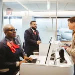a group of people at a desk. American Airlines app update. {Tech} for Travel. https://techfortravel.co.uk