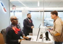 American Airlines app adds hotel and meal vouchers for delays a group of people at a desk. American Airlines app update. {Tech} for Travel. https://techfortravel.co.uk