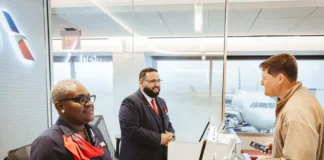 American Airlines app adds hotel and meal vouchers for delays a group of people at a desk. American Airlines app update. {Tech} for Travel. https://techfortravel.co.uk